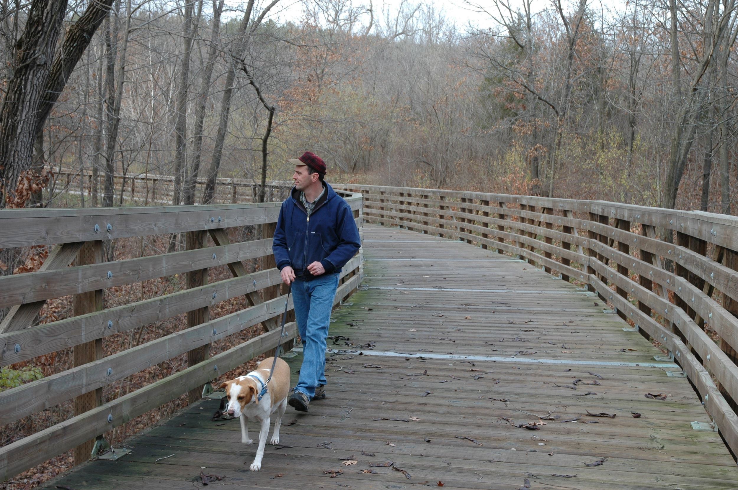 man with dog on trail