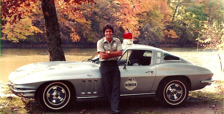 Tom Hazelton as a park ranger in front of a corvette, 1982.