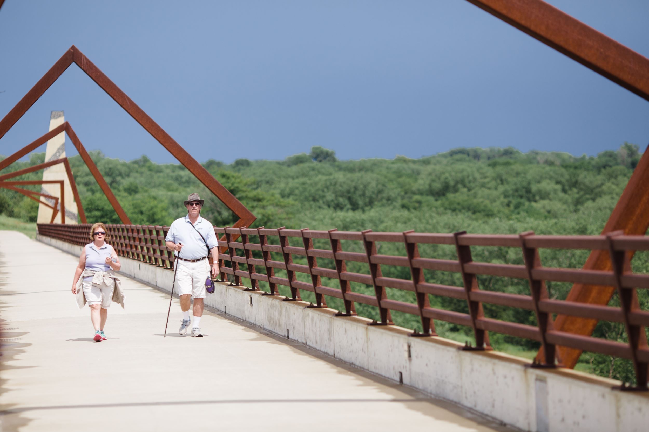 Two people walk across the High Trestle Trail bridge in Madrid