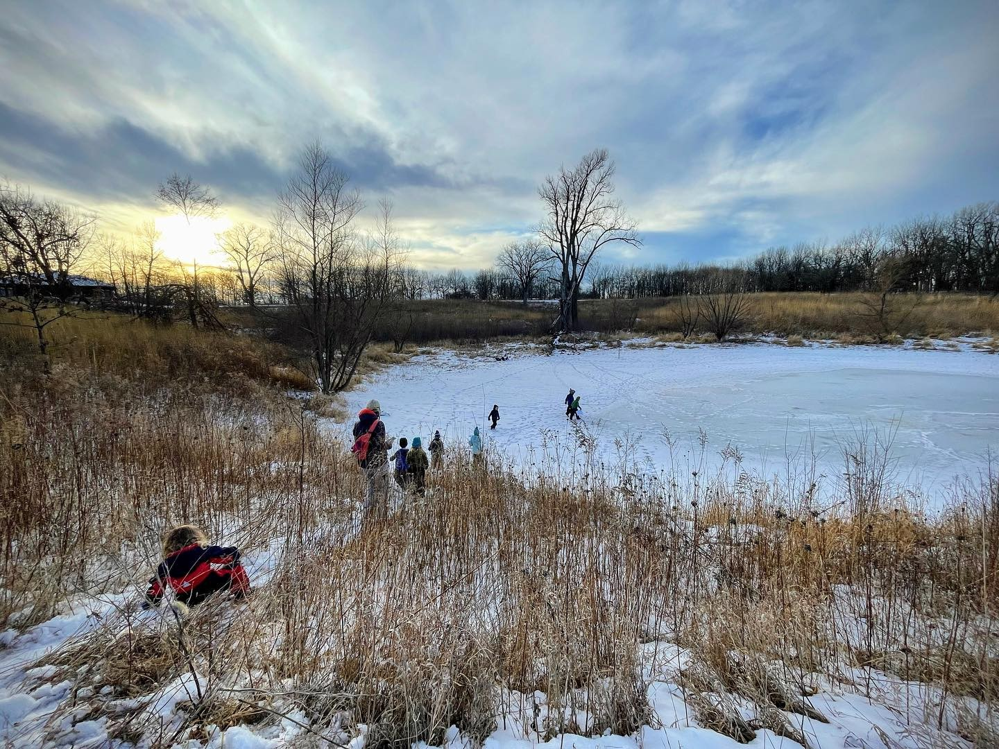 A group of youth explore the frozen ice at F.W. Kent Park in Johnson County.